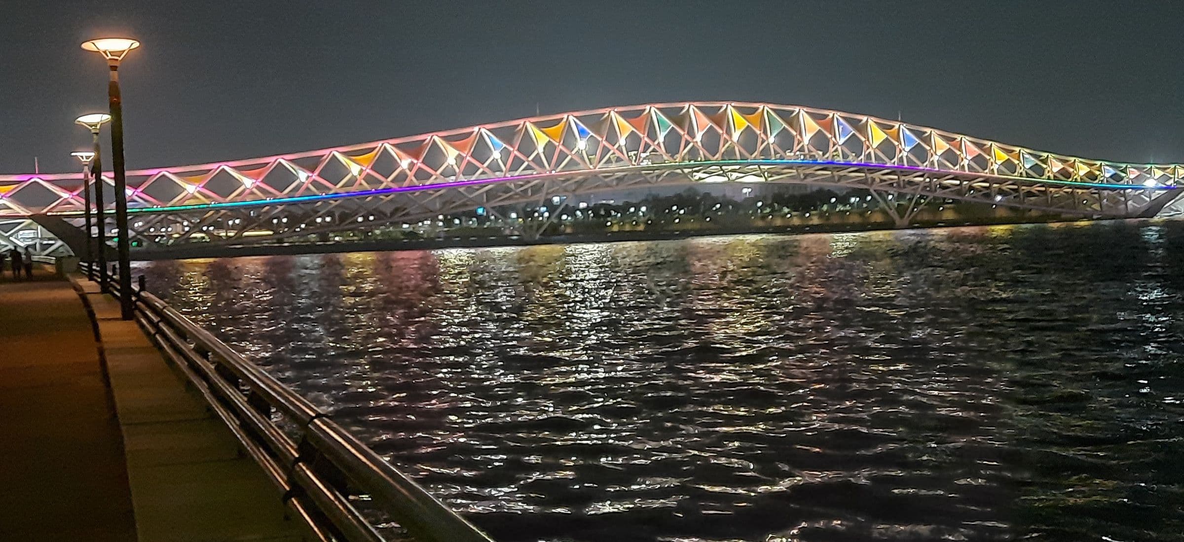 The full span of the Atal pedestrian bridge lit at night over the Sabarmati